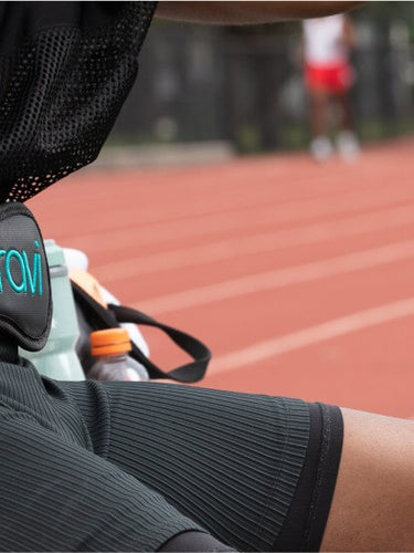 An athlete in the track sporting a Curavi Belt laser therapy device for pain relief and muscle recovery